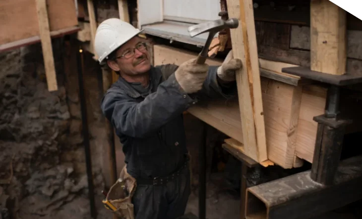 Travailleur ajustant la structure sous un bâtiment
